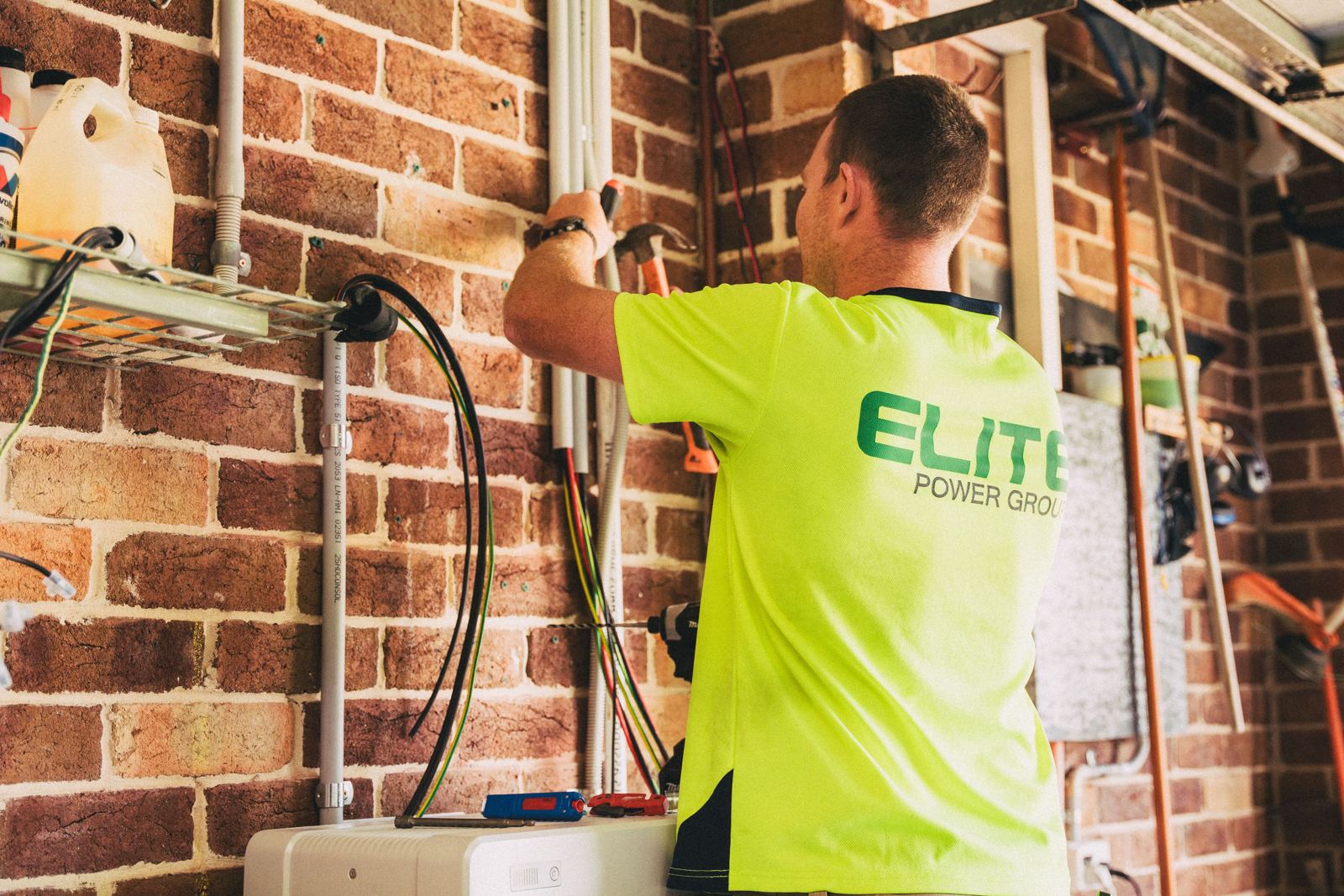 Installer routing electrical conduit and wiring for new heating equipment in a garage