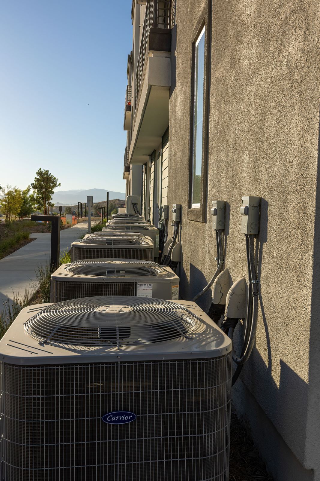Multiple air conditioning condensers serving individual apartments