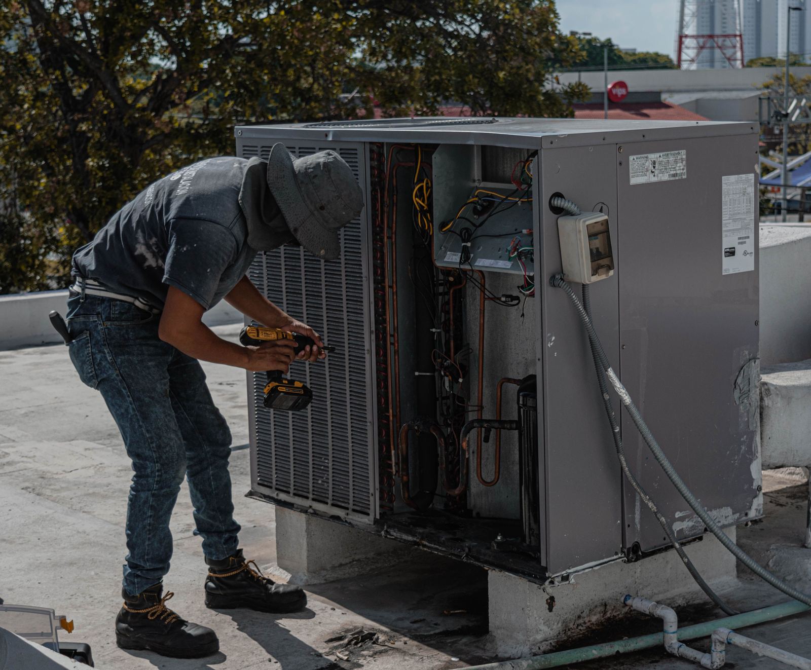 Commercial rooftop HVAC unit being worked on by an installer